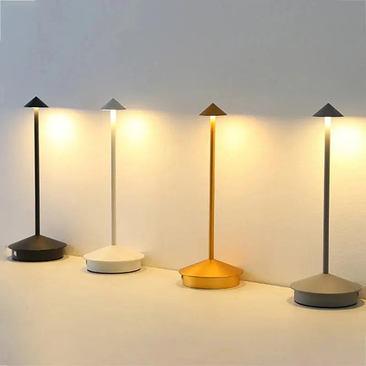 Four modern floor lamps with different base colors on a light gray background