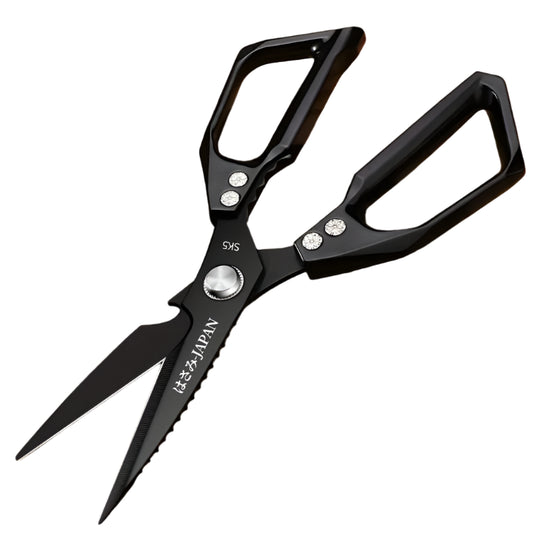 Black kitchen shears on a wooden surface with a fish, lemon, and broccoli.