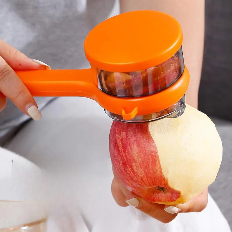 A person using a multifunctional vegetable peeler with storage box to peel an apple.