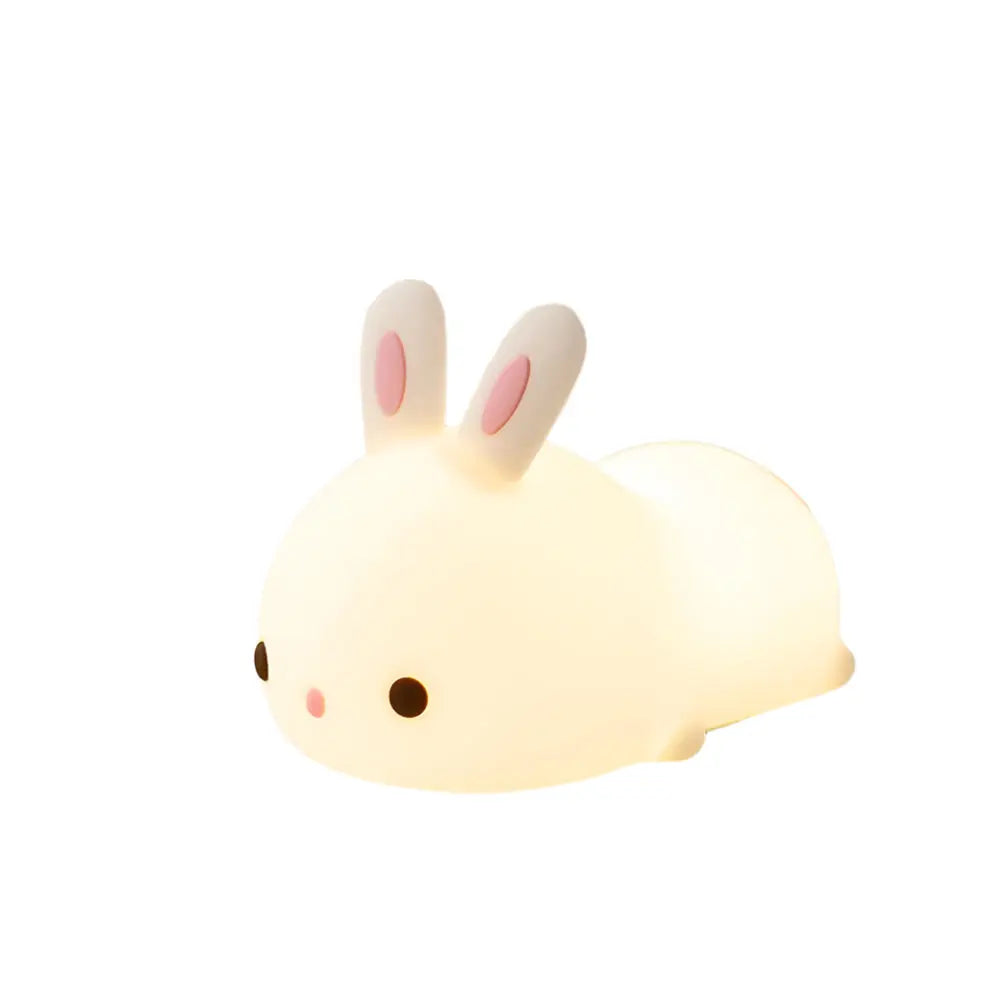 Cute rabbit-shaped night light on a surface with a clock in the background